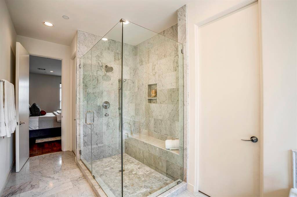 This primary retreat also showcases an expansive glass shower with 2 shower heads and a separate watering room.