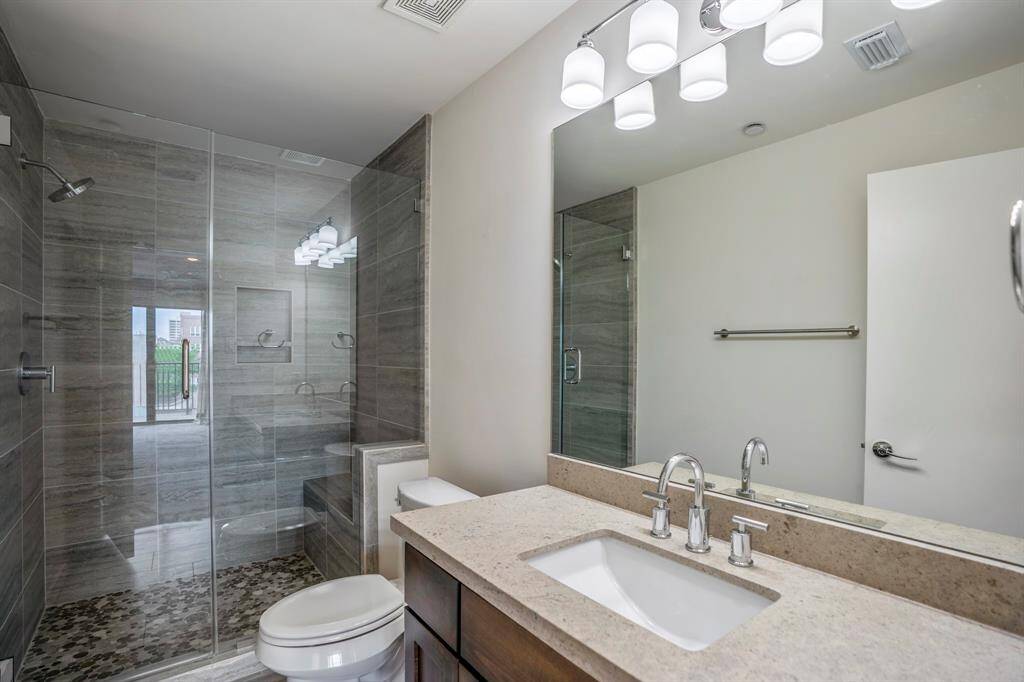 Beautifully modern designed 4th floor bath with stand-up frameless shower door and stone inlaid flooring.