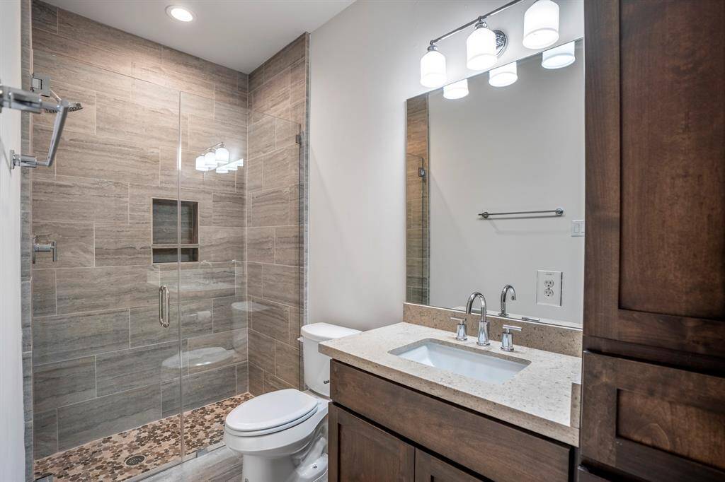 Guest bathroom in secondary bedroom downstairs features a standup shower and granite countertops.