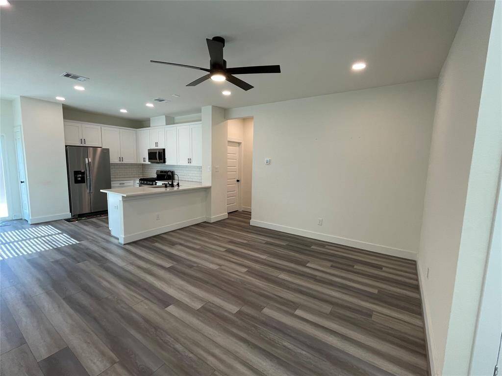 Open Concept kitchen and Family Living Room with lots of natural and LED Light fixture and fan.
