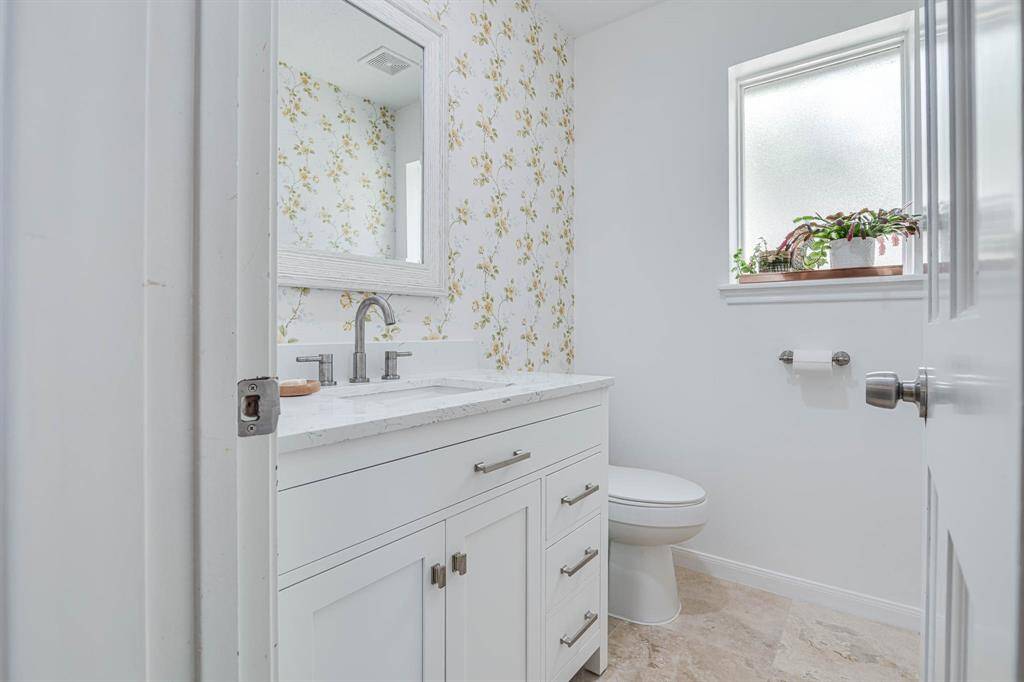 This chic half bath makes a bold design statement with custom wallpaper