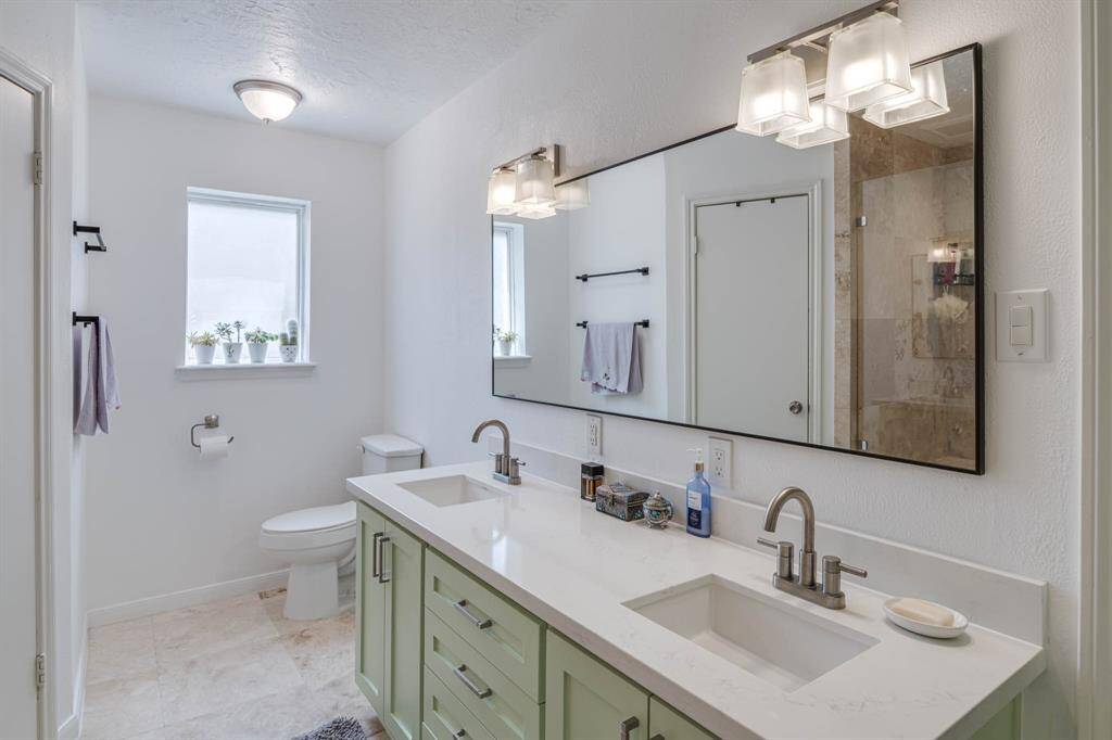 Designed with both style and functionality in mind, the spacious primary bathroom features elegant double sinks set