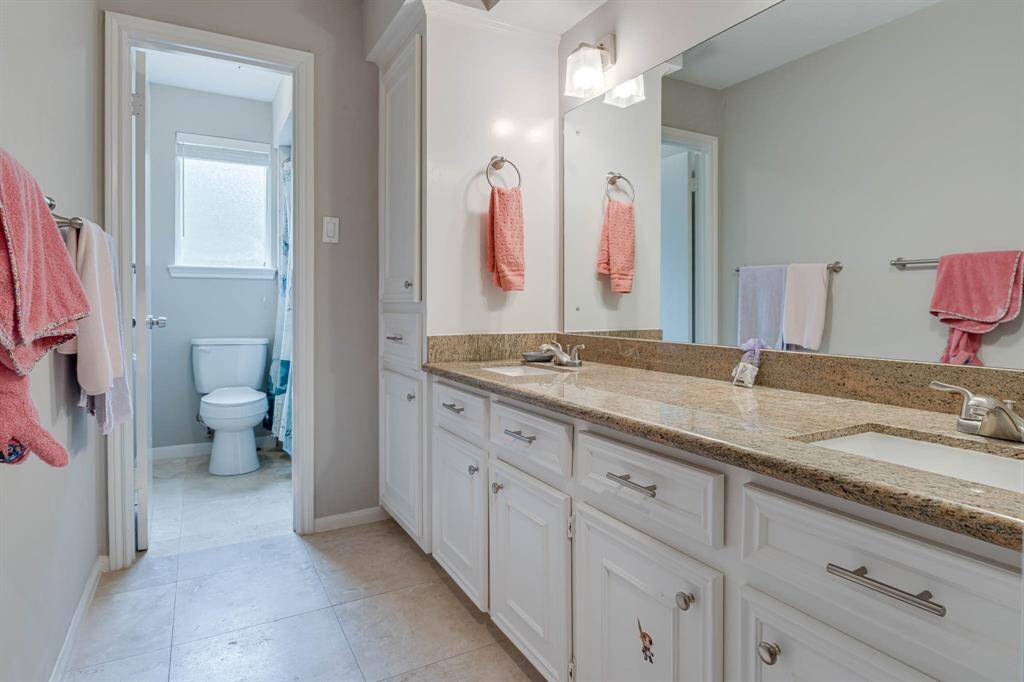 This well-appointed upstairs bathroom includes double vanities with two sinks, perfect for busy mornings and shared spaces