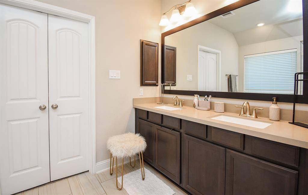 Closer view of the double vanity and framed mirro.