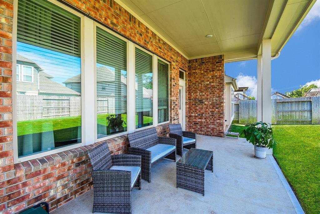 Extended covered patio. Pretty brick exterior and gleaming windows. Enjoy the patio rain or shine.