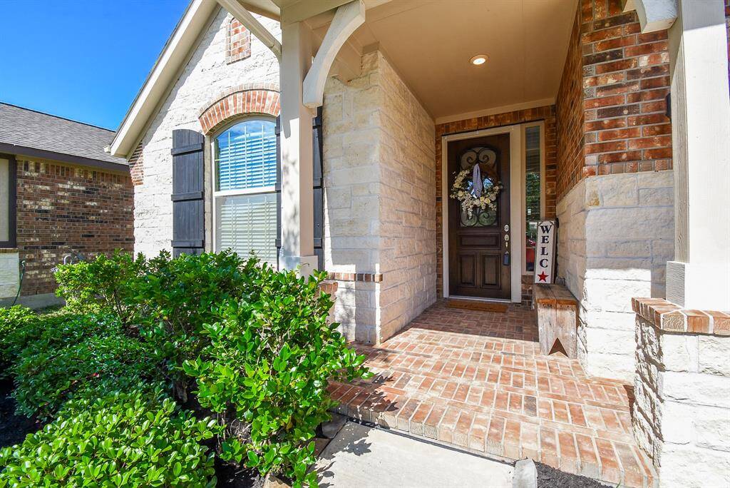 Welcome home, brick pavers and the front door with iron accent are enhanced with the side light allowing natural lighting into the foyer.