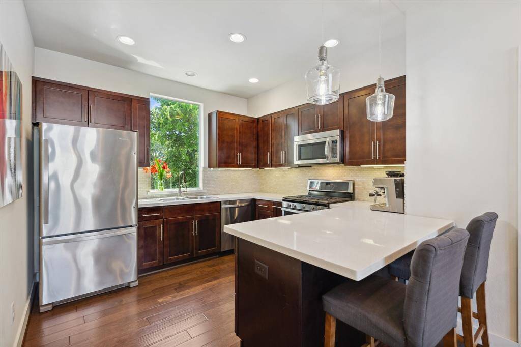 Beautiful hardwood cabinets and stainless steel appliances. Notice lots of extra lighting in this kitchen with countertop dining.