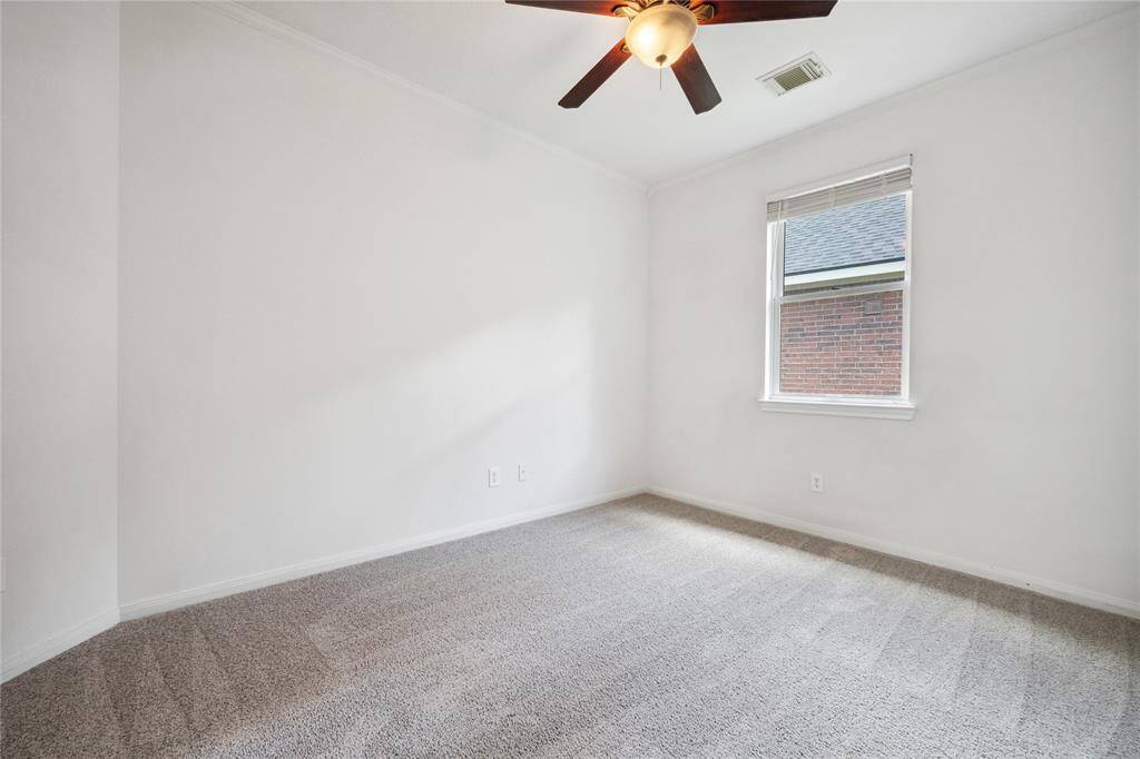 This room off the primary bedroom features neutral walls with plush carpet flooring and a ceiling fan. A window lets in natural light, providing a bright and inviting space. This flex space could be used as a nursery, office or workout space.