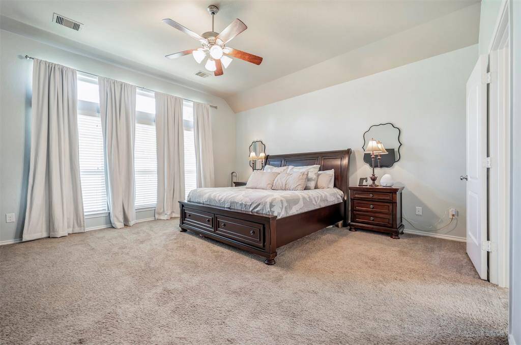 Spacious Primary bedroom with tall ceilings with floor to ceiling windows