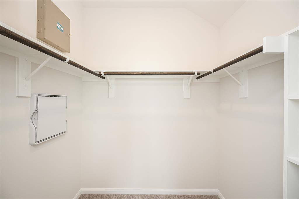 This primary carpeted walk-in closet will store and organize just about everything you own!