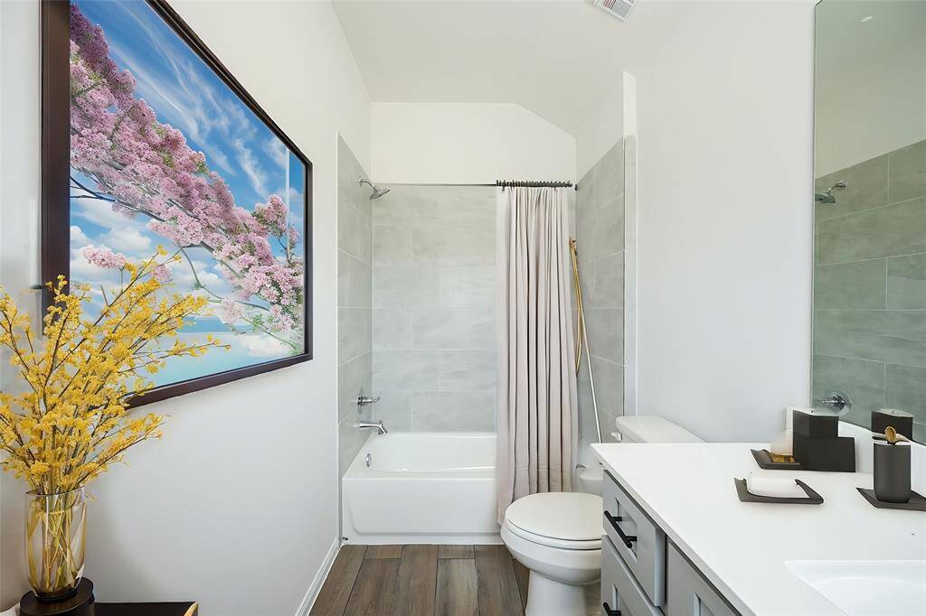 A spotless secondary bath offers the personal preferences in this combined bathtub/shower bath.