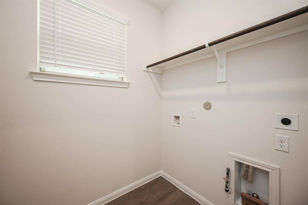 The airy utility room is ready with appliance hook-ups, and offers simple shelving storage, above.