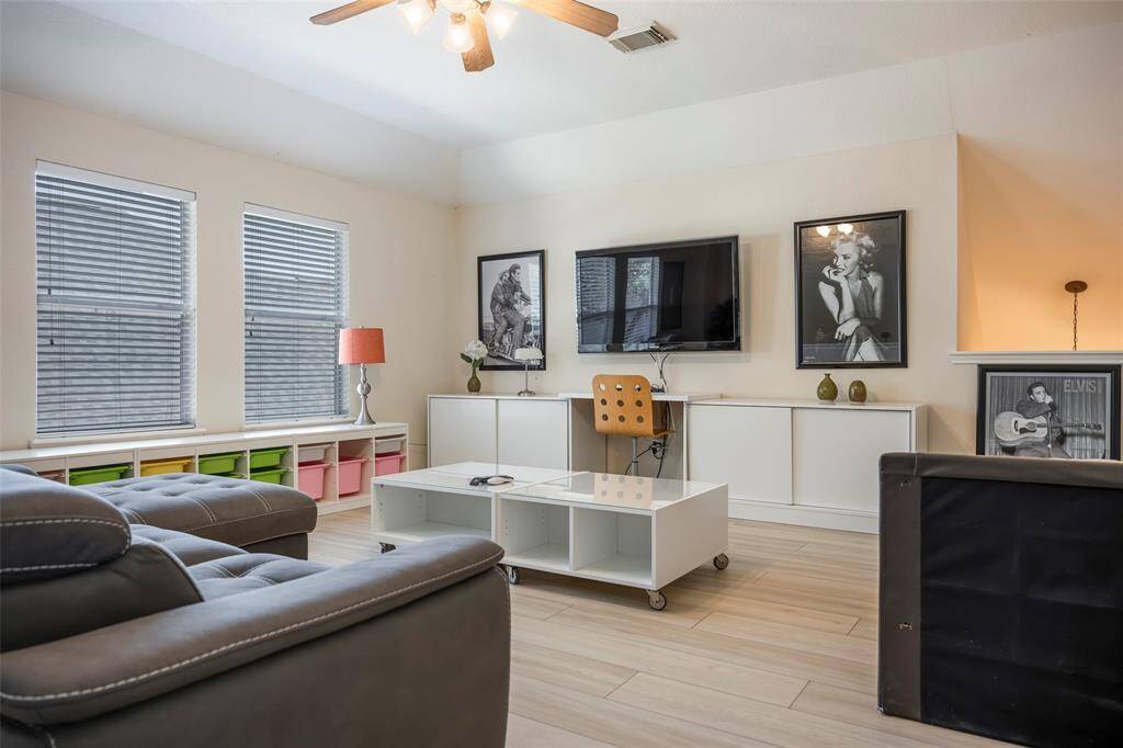 Bright living area with a modern, cozy feel. Large windows provide natural light, complementing the stylish decor and light wood flooring.