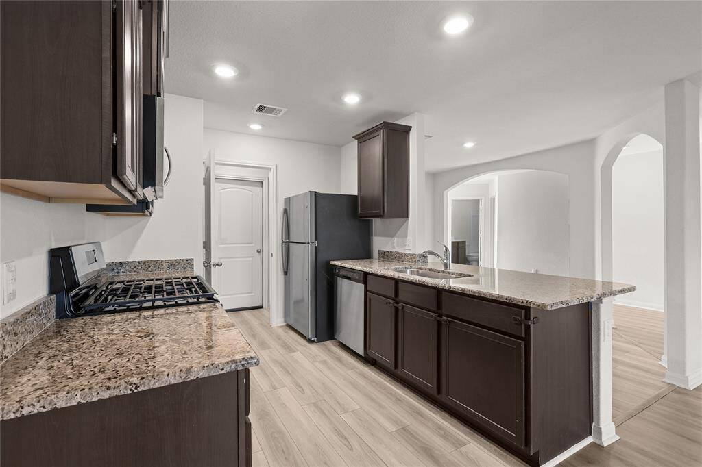 Bright, open-concept kitchen with seamless flow into living areas. Laundry room is located off the kitchen