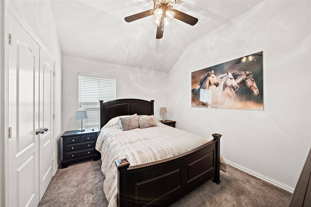 Secondary bedroom with vaulted ceilings and natural light.
