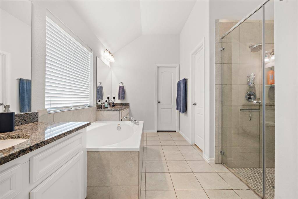 Luxurious primary bathroom featuring a double vanity, separate shower, and inviting soaking tub.