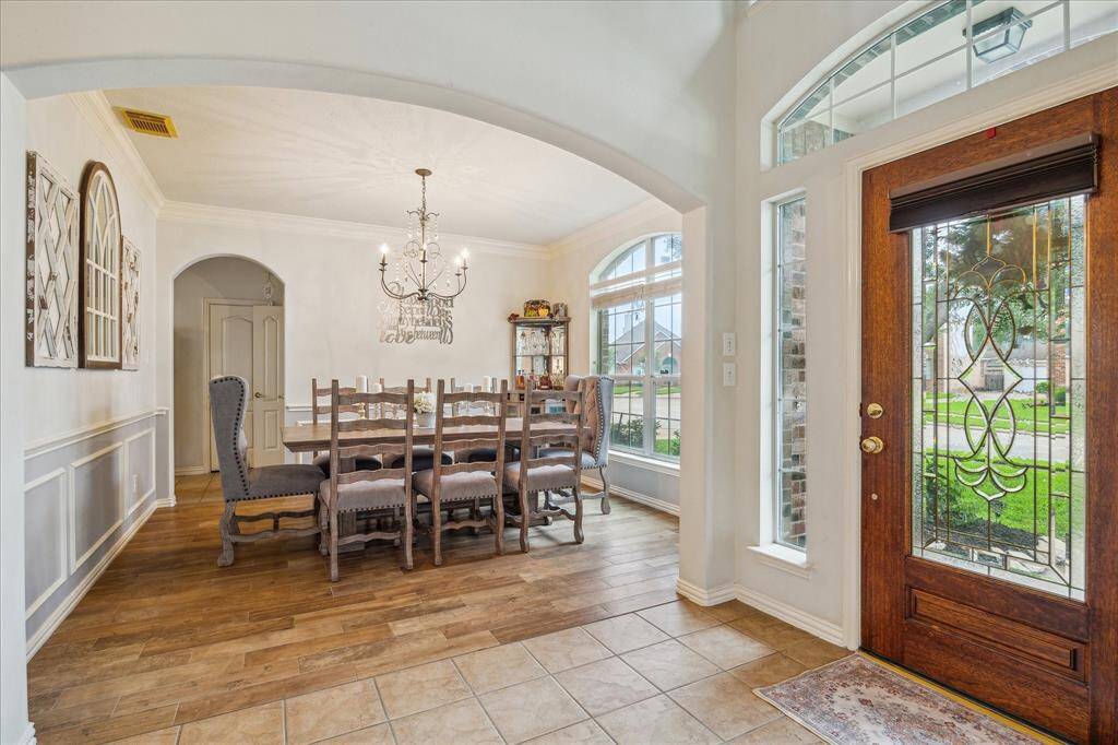 This is a Fabulous Home for those who love to Entertain. This Spacious Dining Room easily accommodates large gatherings with friends and family. So many Upgrades, from the Crown Molding and Decorative Paneling to the Upscale Chandiler and Arched Windows!!!! Did you notice the Stunning Leaded Glass Front Door!!! Bonus ~ Large Nook above front door to display decor.