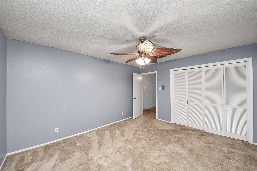 Bedroom 2 – Cozy bedroom with neutral paint, ceiling fan, and a large closet with bifold doors.