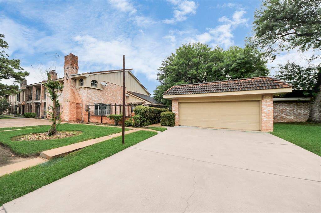 Garage view and corner lotDetached two-car garage with a tile roof complements the home’s architectural style. Corner lot location offers added privacy and accessibility.