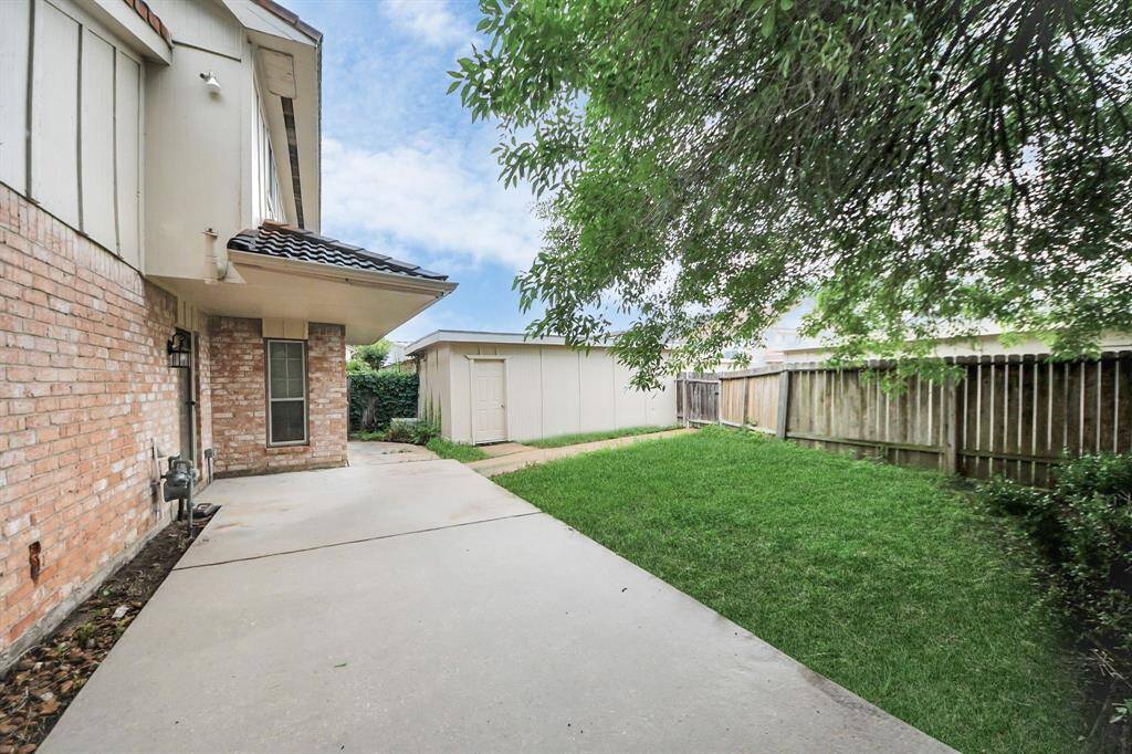 Private backyard with additional car garage-Enjoy a peaceful backyard retreat with a concrete patio, green lawn, mature shade tree, and bonus car garage.