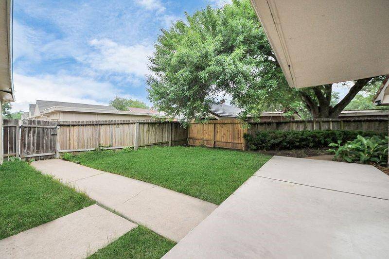 Fenced backyard with walkwayLow-maintenance green space with a privacy fence and shaded patio area—ideal for relaxing mornings or afternoon play.