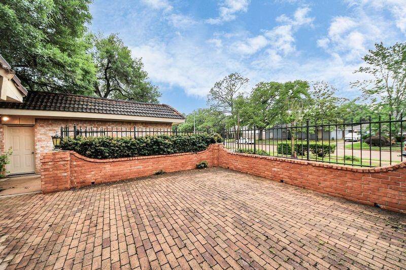 Low-maintenance brick-paved patio enclosed by a privacy wall and iron fencing. This private courtyard is ideal for outdoor lounging, container gardening, or weekend entertaining.