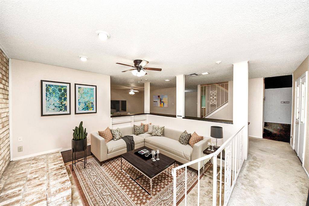 Den: Cozy sunken den featuring brick accent & fireplace. Perfect for movie nights! Virtual staging used to help visualize the space.