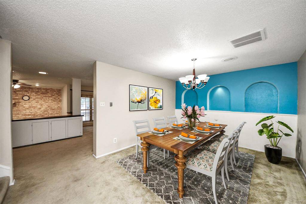 Charming dining room highlighted by a unique accent wall and chandelier—great for hosting dinners and gatherings. Virtual staging used to help visualize the space.