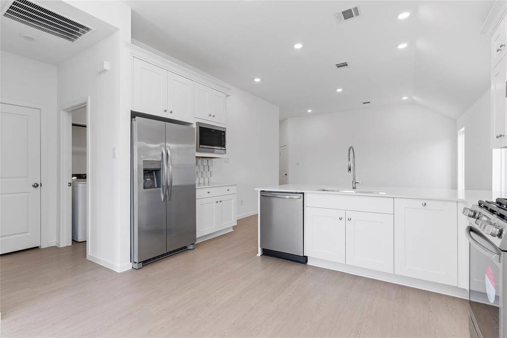 Down the hallway the laundry room!  But first notice how the stainless side by side refrigerator look as if it was built in! Look at all those beautiful cabinets!