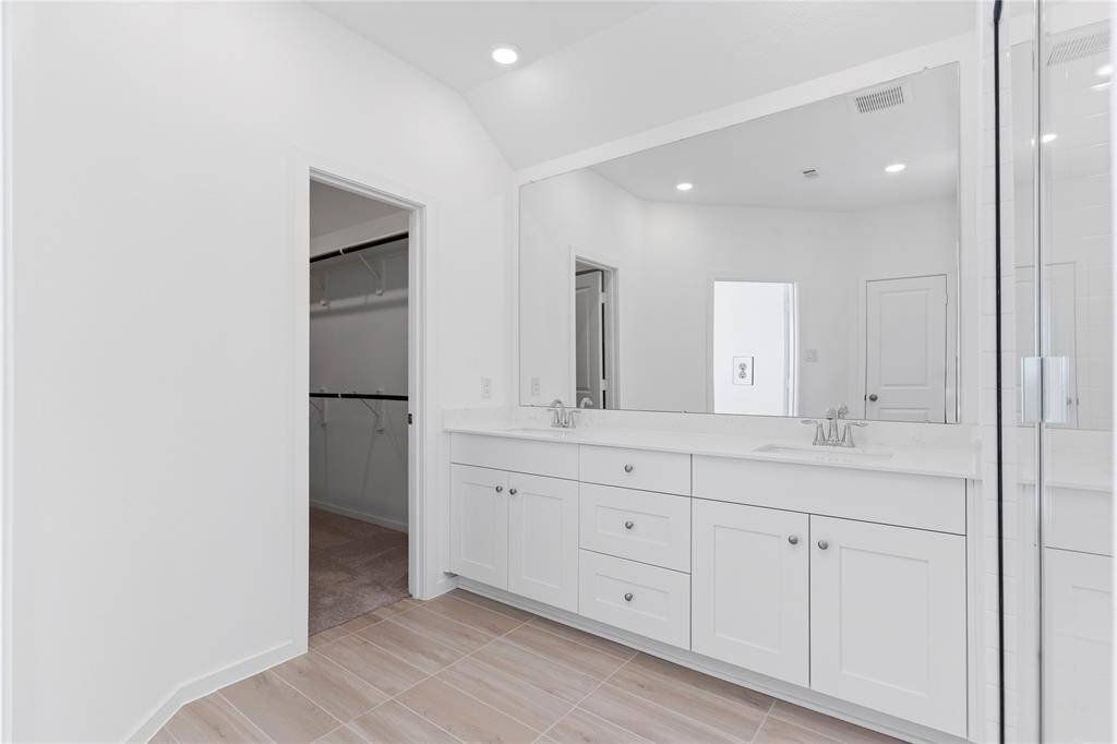 This beautiful Primary Suite Bathroom has quartz countertops with two deep undermount sinks