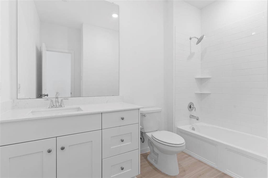 Guest bathroom has a large vanity with quartz countertop, deep undermount sink, lots of draws for all your storage needs with a tub and shower combination!