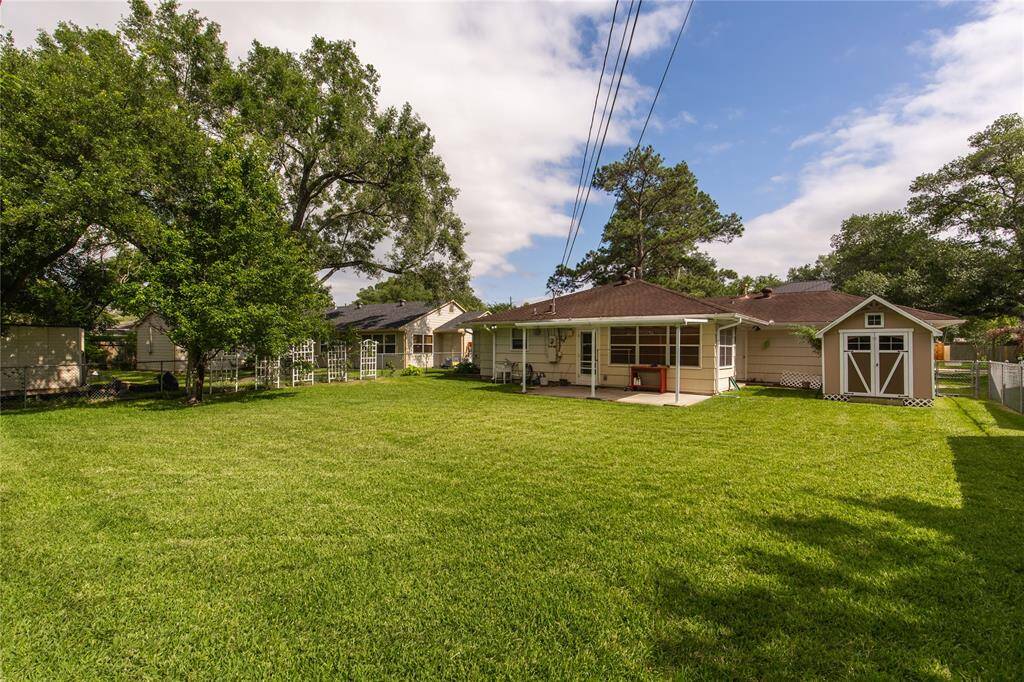 Look at the size of this yard!  Someone will have fun tossing footballs or just relaxing on the outdoor covered patio!  Please note the storage shed on the right! Behind is the attached 2 car garage.
