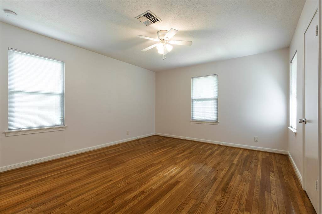 Bedroom #3 again with chandelier, large windows and blinds and closet.