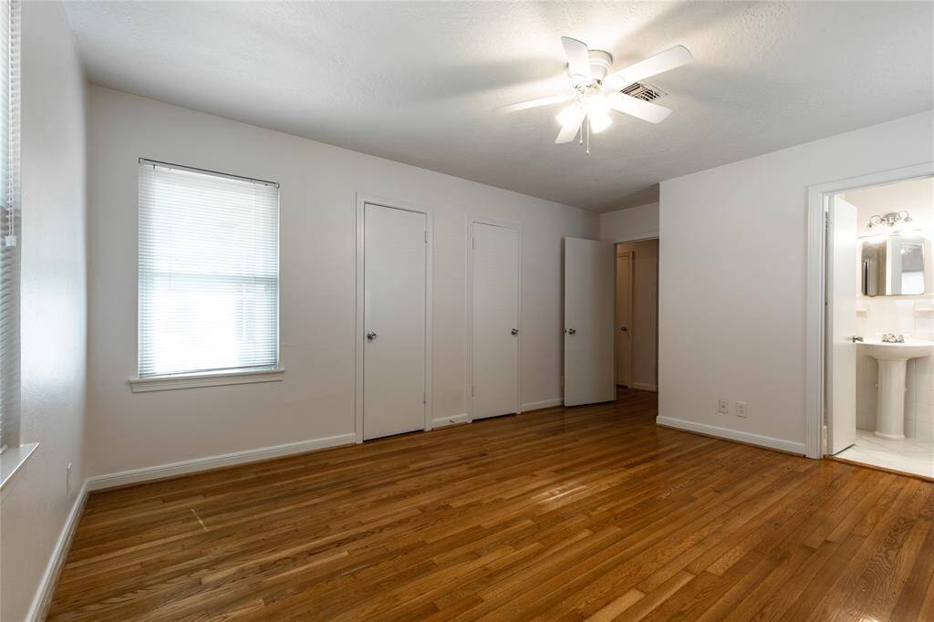 The primary bedroom has an en-suite bath, wood floors, ample closets and large windows.