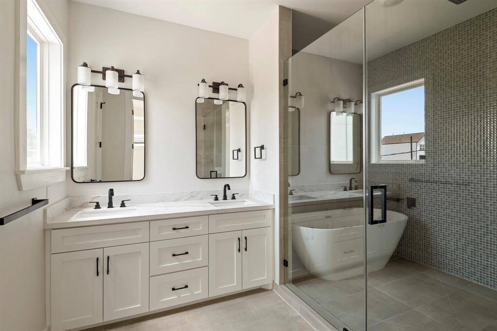 A stunning freestanding soaking tub paired with a sleek rainfall shower, set against a striking accent wall for a touch of luxury and elegance.