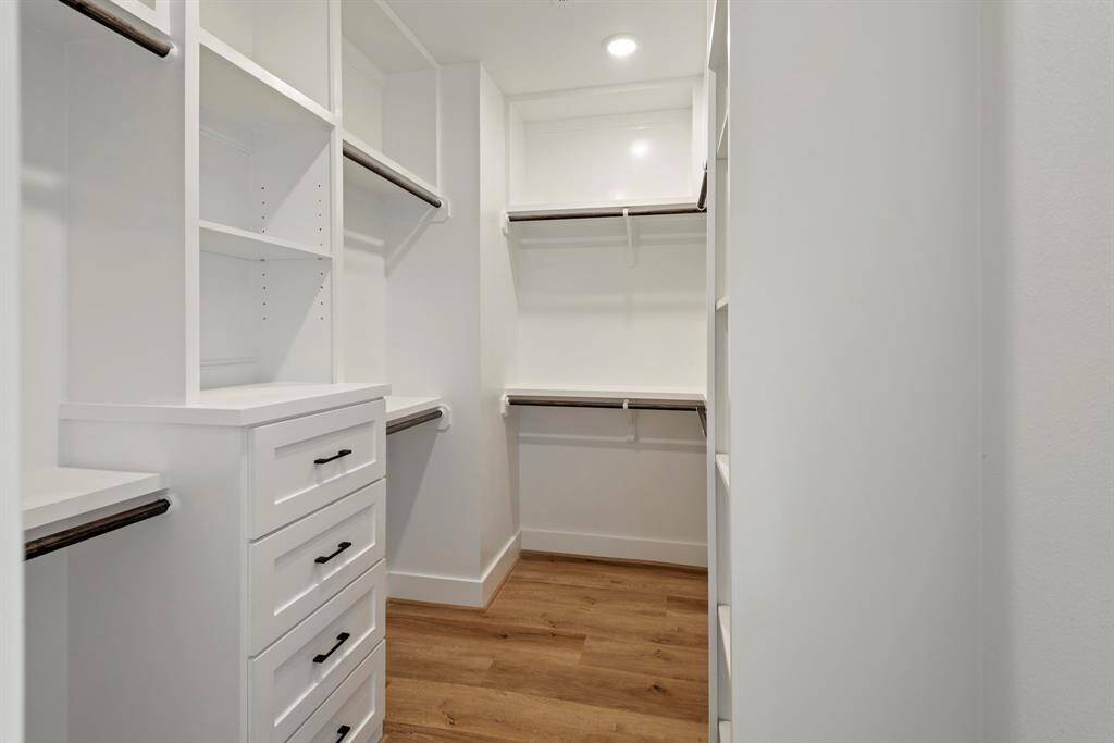 A spacious, extended closet featuring abundant shelving and ample storage, designed for optimal organization and convenience.