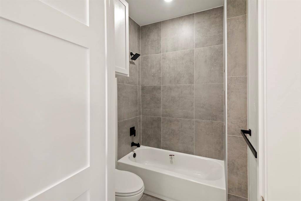 A well-appointed guest bathroom serves family and visitors with ease, featuring calming neutral tones and a convenient tub.