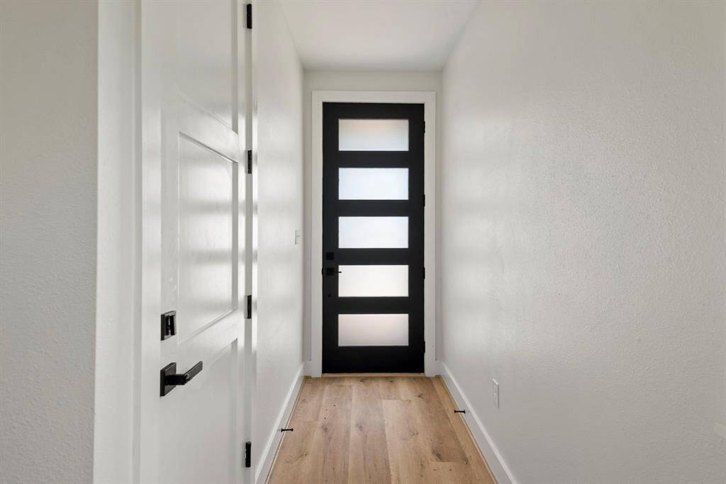 A contemporary front door opens to reveal a bright entryway that sets the perfect first impression.