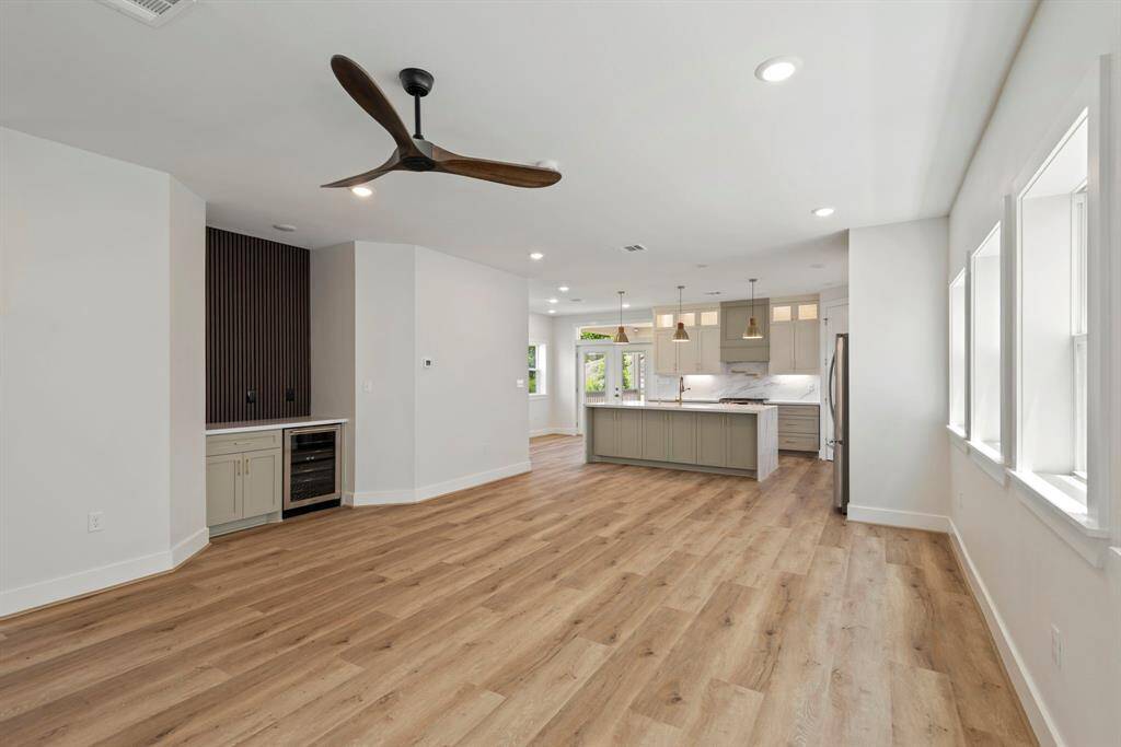 Kitchen and living room blend seamlessly in this inviting space, creating the perfect spot for family gatherings or quiet evenings at home. Make memories in this perfect entertainment spot, featuring a beautiful accent wall, convenient dry bar, and wine fridge!