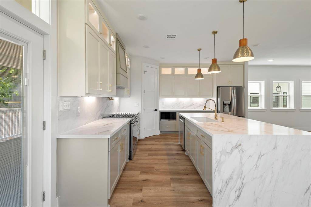 High-end appliances make cooking a joy, while designer lighting adds that perfect sparkle. Every detail, from the premium finishes to the thoughtful upgrades, makes this space special.