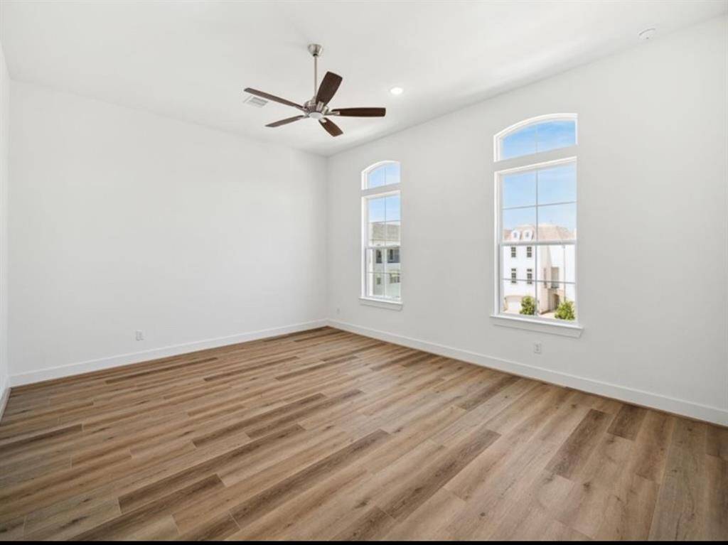 Here is a view of one of our primary bedrooms, boasting, gorgeous hardwoods and high ceilings.