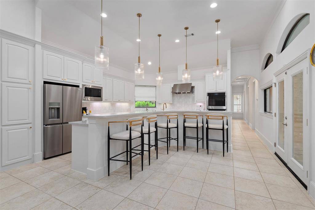 Updated kitchen with bar seating and direct access out the double doors to the summer kitchen.