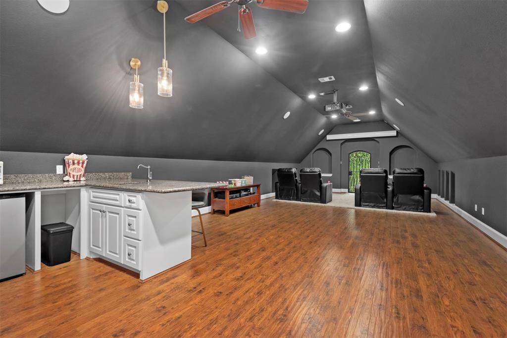 HUGE theater/media room. This space is amazing with a built in beverage, snack bar. Projector and screen stays.