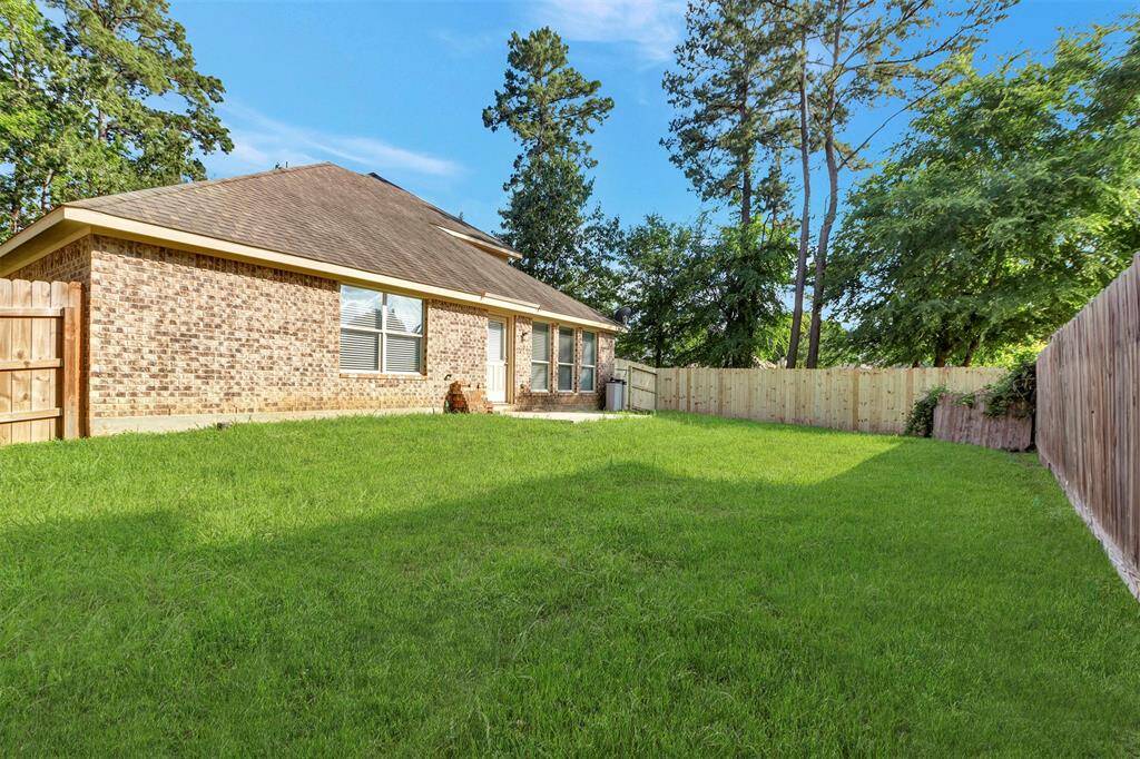 Spacious backyard with new fence next to green space