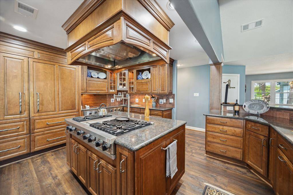 A built-in side-by-side Subzero Refrigerator/Freezer with matching cabinetry trim is on the rear wall of the kitchen.