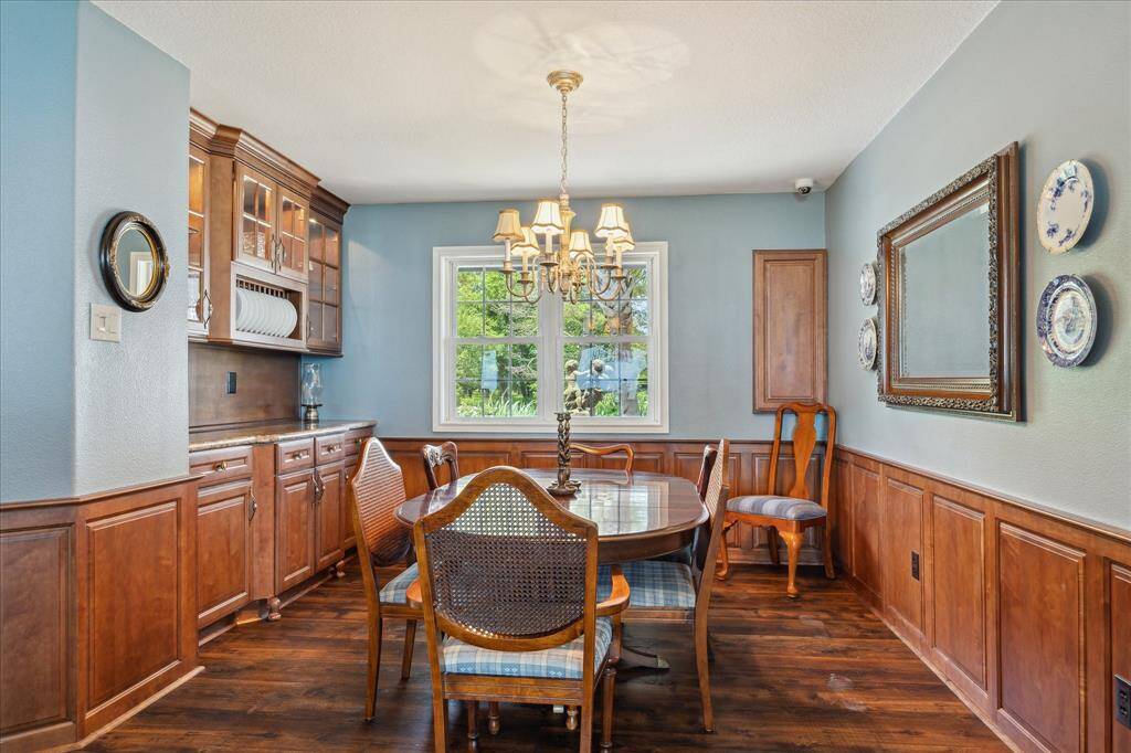 The formal dining room features a built-in buffet with granite top, upper glass front cabinets, plate/china cabinet and engineered wood flooring,
