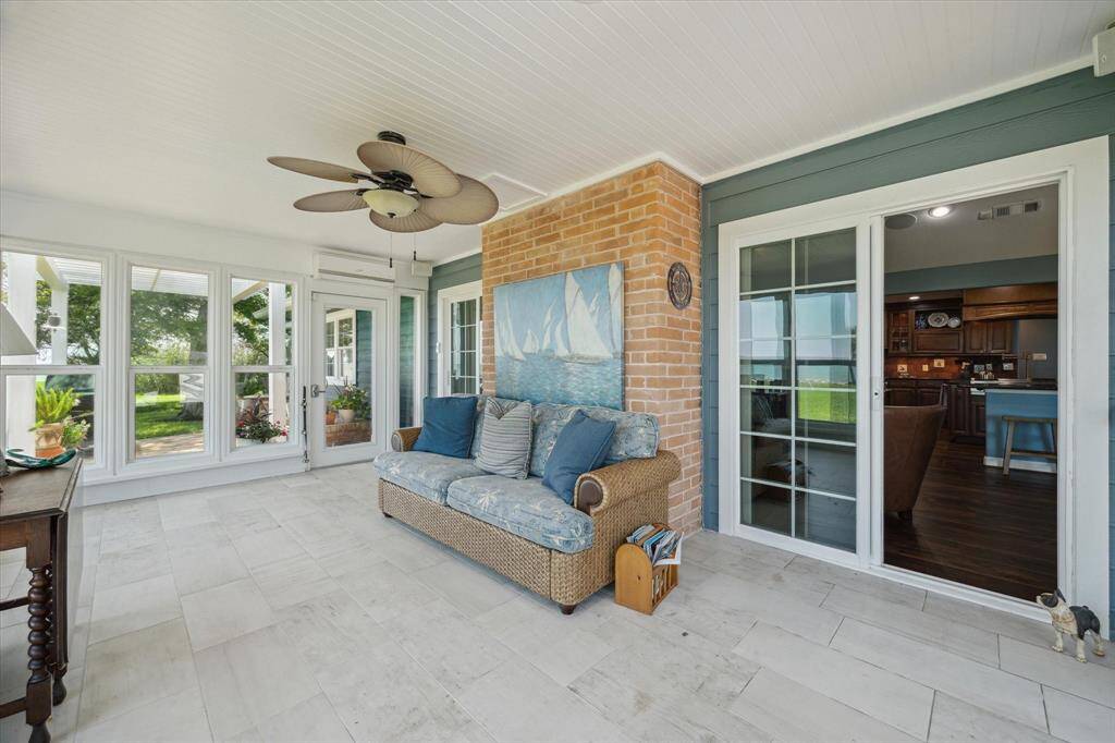 The sunroom is accessed by double slider doors leading from the den and is equipped with a mini-split HVAC system. Access to the outside patio areas is provided by doors at each side of the sunroom.