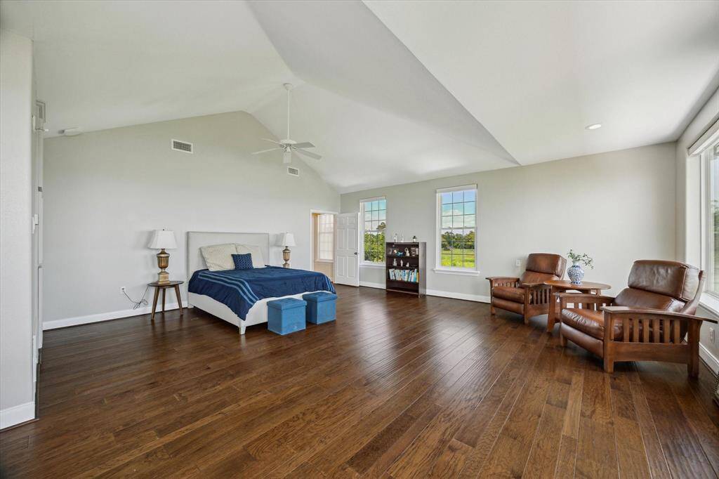 Vaulted ceiling & engineered wood floor are features of the primary bedroom.