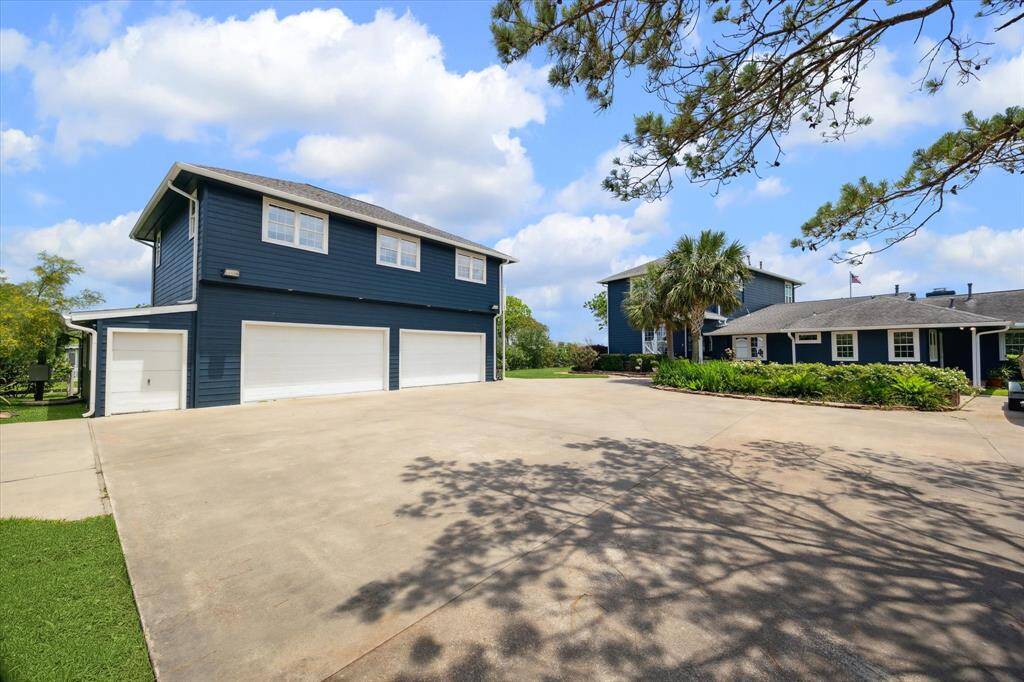 The 4-car garage has double 2-car entry doors and additional space at the rear and each side. It has a full 1 bedroom apartment above. Expansive concrete surface parking offers lots of space.