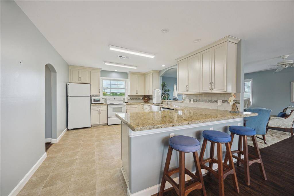 The apartment kitchen has a large breakfast/serving bar, tile floor, 42" upper cabinets, granite counter tops, electric range, dishwasher and arched serving window into the family room.